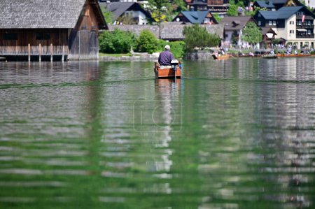 Foto de Un pequeño barco de motor en el lago Hallstatt con las olas típicas - Imagen libre de derechos