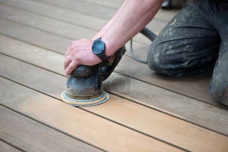 Photo for Sanding process of wooden terrace floors. Sanding machine remove imperfections. Rejuvenation and maintenance of outdoor wooden flooring, wood restoration. - Royalty Free Image