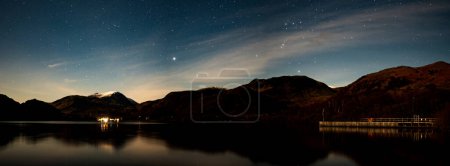 A panoramic view of the night sky over Aira Force Steamer pier on Ullswater on a winters night