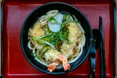 Téléchargez les photos : Tempura de crevettes Udon : Une délicieuse combinaison de tempura de crevettes croustillant et épais, nouilles udon mâché, servi dans un bouillon savoureux et réconfortant. - en image libre de droit