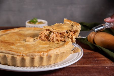 Téléchargez les photos : Tranche de tarte au poulet sur fond de bois rustique - en image libre de droit