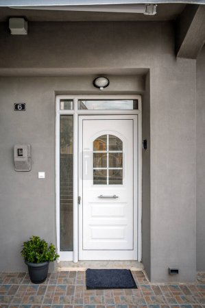 Entrance White Door with Window to House, Villa, or Apartments in Grey Color. Perfect for showcasing architectural features, home exteriors, and real estate concepts. Ideal for advertisements.