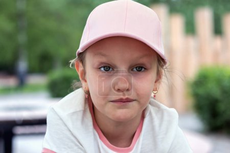 Photo for Portrait of a cute beautiful girl 7-9 years old with a pensive look in a pink baseball cap - Royalty Free Image