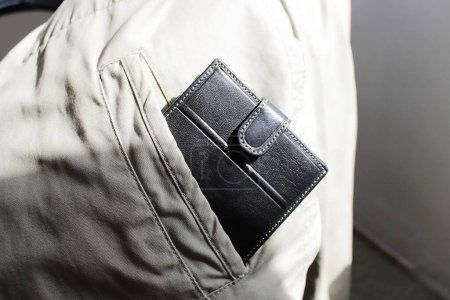 Photo for Black wallet stick out from the pocket of a white jacket - Royalty Free Image