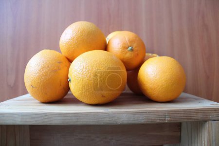 Oranges in a pile on a wooden bench