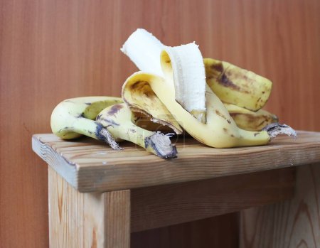Peeled banana on wooden table