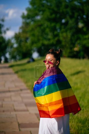 Téléchargez les photos : Jeune femme avec drapeau de fierté lgbt dans le parc. - en image libre de droit