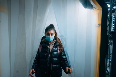 Foto de Young beautiful woman in a medic mask is staying in a disinfection tunnel - Imagen libre de derechos