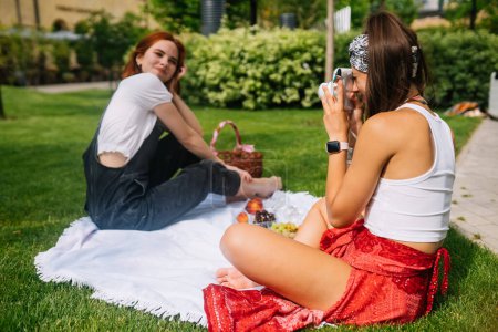 Photo for Woman takes photo of girlfriend using camera - Royalty Free Image