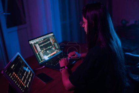 Foto de Attractive young woman working in home at night. Girl using laptop. - Imagen libre de derechos