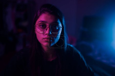 Photo for Young brunette woman working at the office at night with serious expression on face. Simple and natural looking at the camera. - Royalty Free Image
