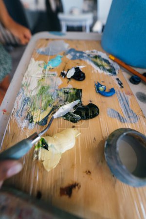 Téléchargez les photos : Peintures mélangées à la main en palette dans la classe d'art - en image libre de droit
