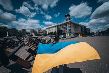 Téléchargez les photos : Une jeune femme porte le drapeau de l'Ukraine flottant derrière elle dans la rue - en image libre de droit