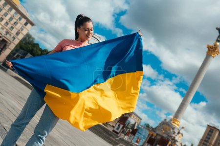 Téléchargez les photos : Jeune femme tenant le drapeau national de l'Ukraine dans la ville - en image libre de droit