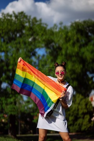 Téléchargez les photos : Young woman with lgbt pride flag in the park. - en image libre de droit