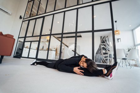 Téléchargez les photos : Side view of flexible girl exercising yoga pose indoors. Concept of yoga. - en image libre de droit