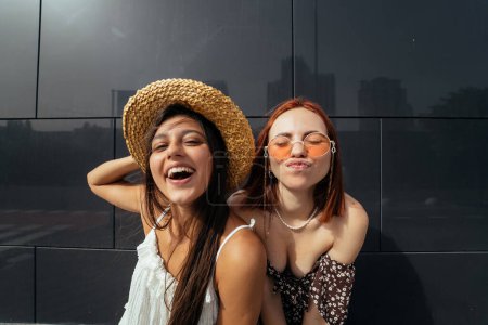 Photo for Two attractive young women fooling around in fresh air. Summer playful mood concept - Royalty Free Image