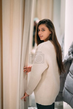 Photo for A girl trying on a white sweater - Royalty Free Image