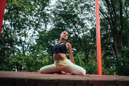 Foto de Una joven haciendo yoga en el patio de la terraza - Imagen libre de derechos