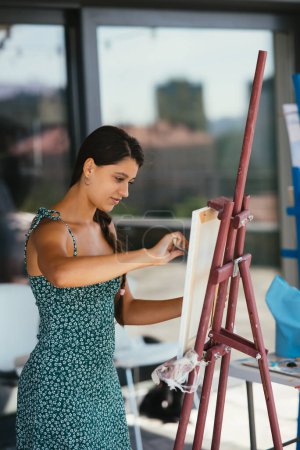 Photo for Female artist painting picture in workshop - Royalty Free Image