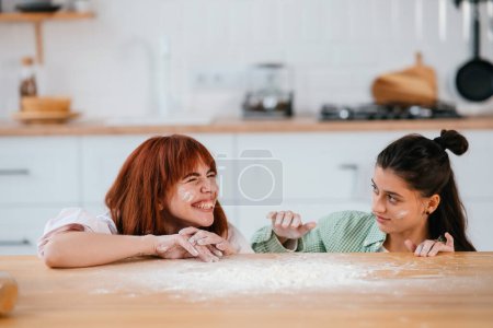 Foto de Las mujeres juegan con harina en la cocina - Imagen libre de derechos