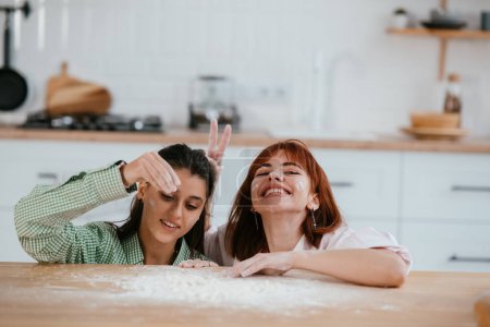 Foto de Las mujeres juegan con harina en la cocina - Imagen libre de derechos