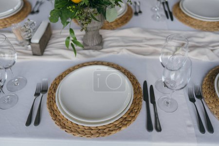 Foto de Mesa festiva en la fiesta de bodas están decoradas con arreglos de limón, en la mesa hay platos con servilletas y vasos - Imagen libre de derechos