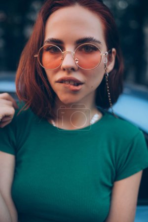Téléchargez les photos : Jeune femme en lunettes posant près de la voiture - en image libre de droit