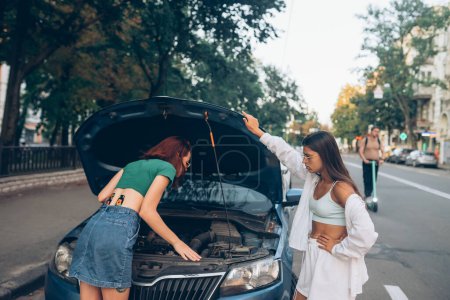 Photo for Women with broken down car on the road. Look for someone help. - Royalty Free Image