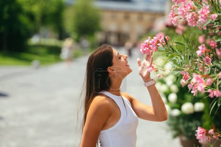Photo for Outdoor portrait of young beautiful lady posing near flowering tree. Female beauty and fashion. City lifestyle. Copy space - Royalty Free Image