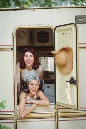 Foto de Amigos hippies felices están pasando un buen rato juntos en caravana remolque. Vacaciones, vacaciones, concepto de viaje. Foto de alta calidad - Imagen libre de derechos