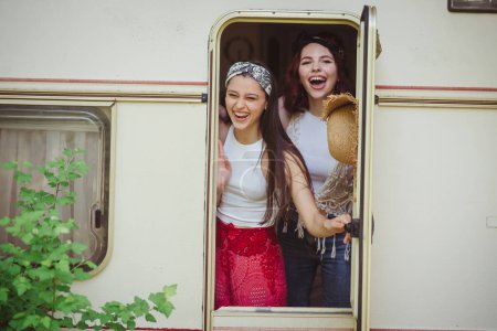 Glückliche Hippie-Freunde amüsieren sich gemeinsam im Wohnwagen. Urlaub, Urlaub, Reisekonzept. Hochwertiges Foto
