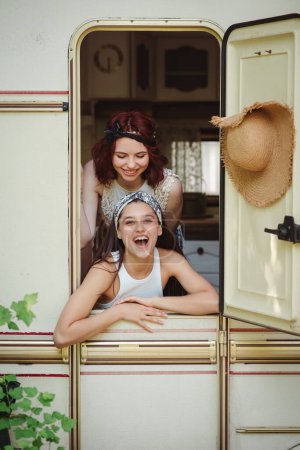 Glückliche Hippie-Freunde amüsieren sich gemeinsam in einem Wohnwagen. Urlaub, Urlaub, Reisekonzept. Hochwertiges Foto