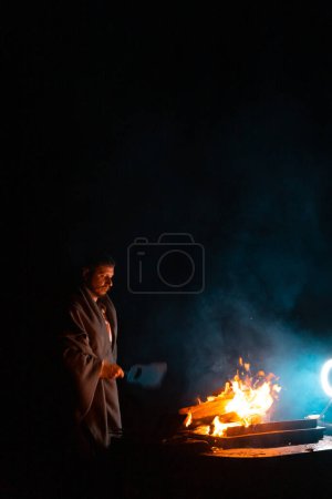 Photo for Man preparing bbq grill to cook on fire. Outside dark shot. Freeze moment of fire. High quality photo - Royalty Free Image