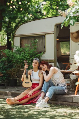 Photo for Happy hippie friends are having a good time together in camper trailer. Holiday, vacation, trip concept. High quality photo - Royalty Free Image