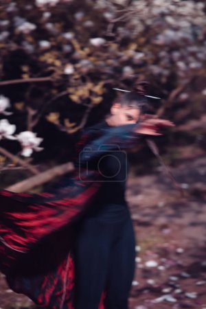 Téléchargez les photos : Belle jeune femme dramatique portant kimono levant les mains pour cacher son visage avec des fleurs de cerisier, vue sakura. Photo de haute qualité - en image libre de droit