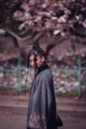 Foto de Hermosa joven dramática que usa kimono con flores de cerezo, vista de sakura. Foto de alta calidad - Imagen libre de derechos