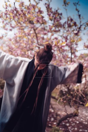 Photo for Beautiful dramatic young woman wearing kimono with cherry blossoms, sakura view. High quality photo - Royalty Free Image