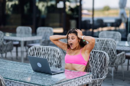 Téléchargez les photos : Jolie jeune femme assise sur la terrasse, tout en utilisant un ordinateur portable pour le travail le jour d'été - en image libre de droit