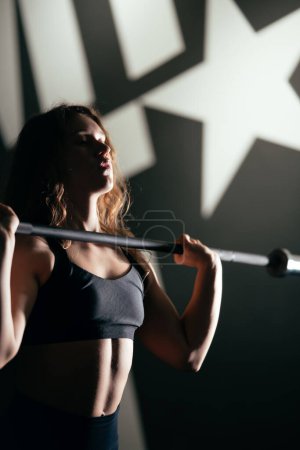 Foto de Atlética hermosa mujer con barra, levantamiento de pesas gimnasio rutina de entrenamiento - Imagen libre de derechos