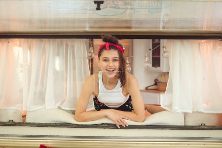 Photo for Happy hippie girl are having a good time in a camper trailer. Holiday, vacation, trip concept.High quality photo - Royalty Free Image