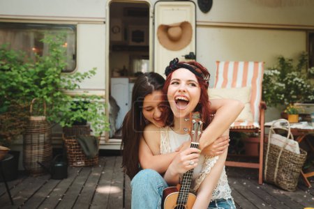 Happy hippie friends are having a good time together in camper trailer. Holiday, vacation, trip concept. High quality photo
