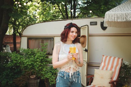 Foto de Chica hippie feliz se están divirtiendo con la taza de té en un remolque campista. Vacaciones, vacaciones, concepto de viaje.Foto de alta calidad - Imagen libre de derechos