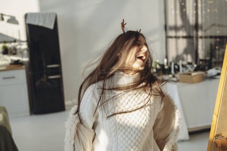 Photo for Surrounded by sunlight, a bright young lady dons a Christmas reindeer mask. High quality photo - Royalty Free Image