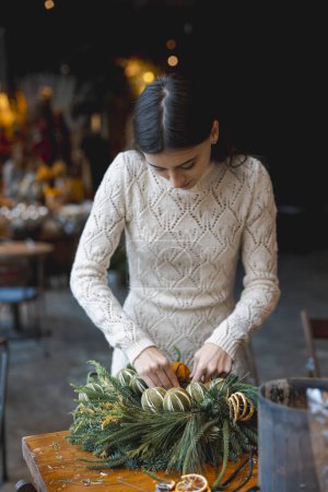 Foto de En una clase magistral de artesanía, una joven aprende a hacer decoraciones navideñas. Foto de alta calidad - Imagen libre de derechos