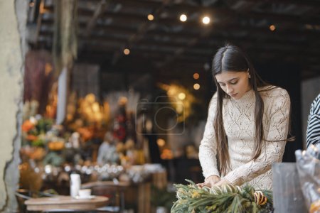 Photo for The final stages of crafting the Christmas wreath showcased on the flower shop counter. High quality photo - Royalty Free Image