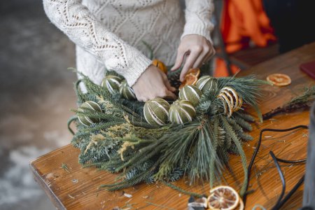 Téléchargez les photos : Une jeune femme participe activement à un atelier de confection d'ornements de Noël. Photo de haute qualité - en image libre de droit