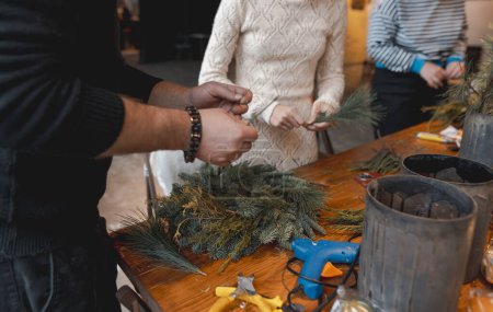 Téléchargez les photos : Une jeune femme participe à un atelier d'artisanat, fabriquant des ornements de Noël festifs. Photo de haute qualité - en image libre de droit
