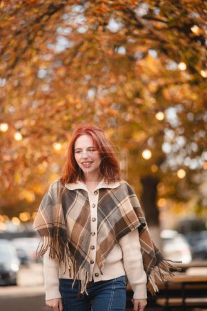 Photo for A delightful redhead smiles brightly, adding a touch of happiness to the autumn streets. High quality photo - Royalty Free Image