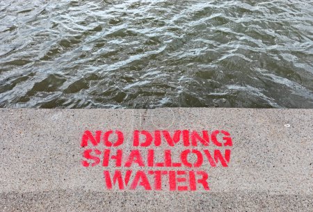 Photo for A stencilled sign warning swimmers not to dive into the Marine Lake in Weston-super-Mare, UK - Royalty Free Image